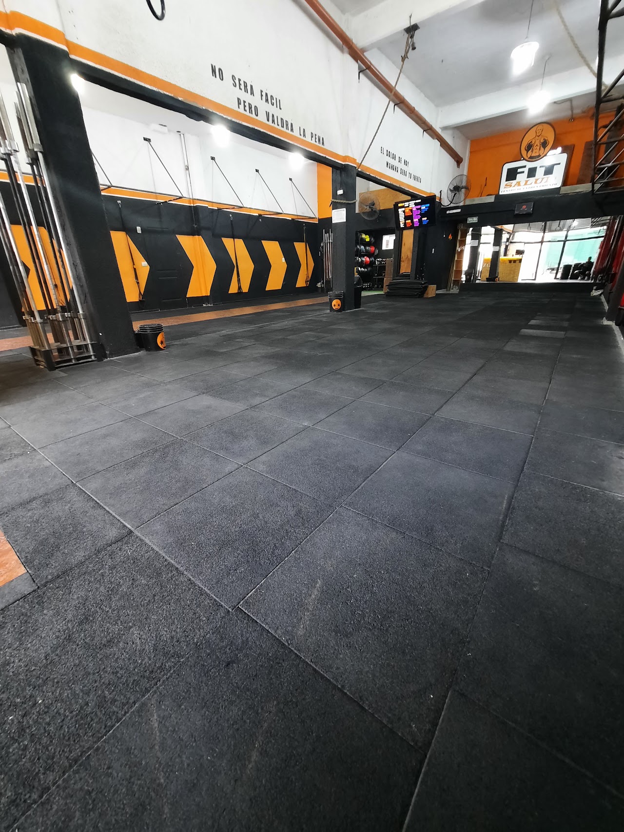 Zona de clases con anillas y mural motivacional en FIT SALUD